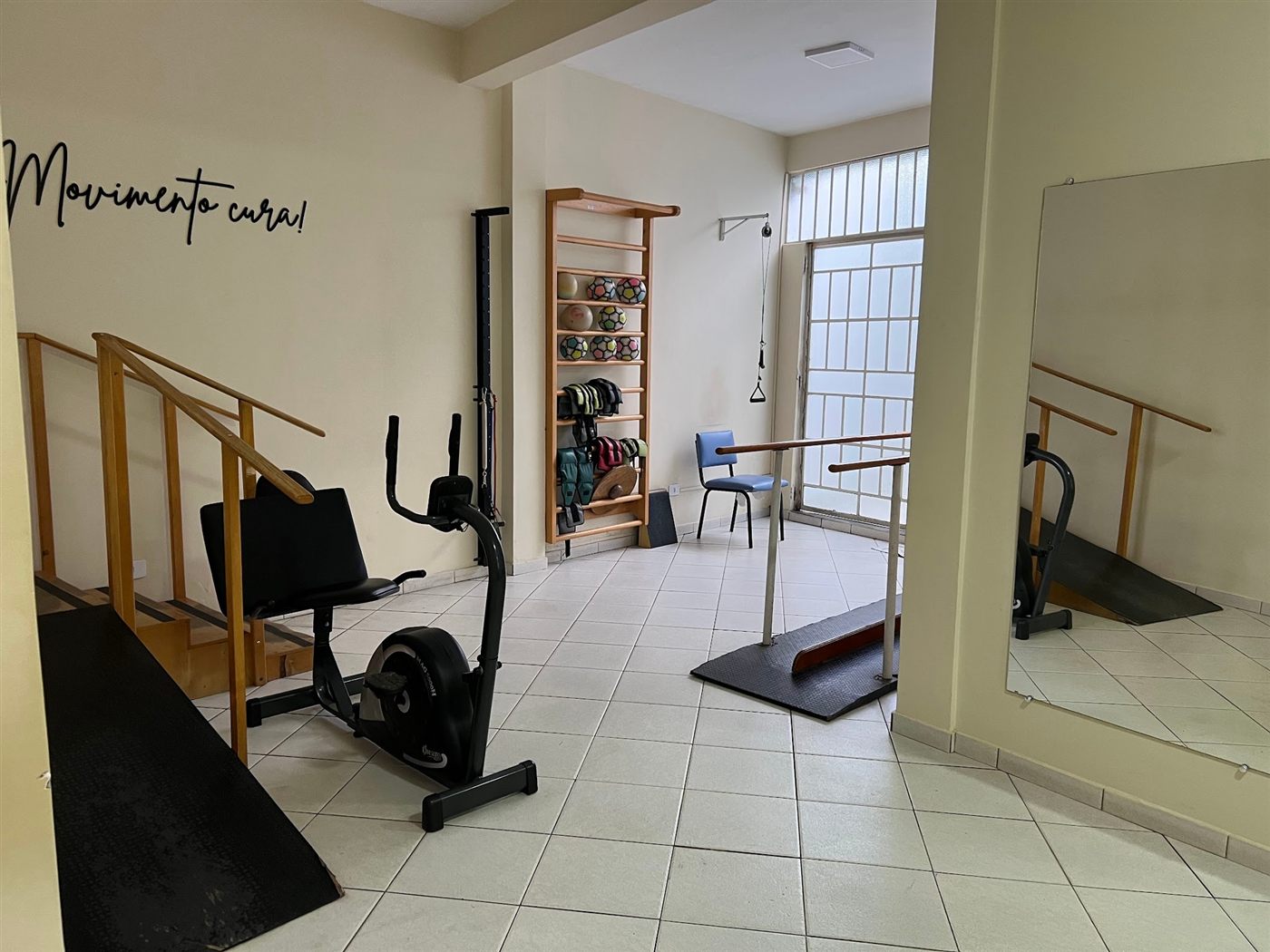 Espaço com bicicleta, espaldar e a frase Movimento cura
